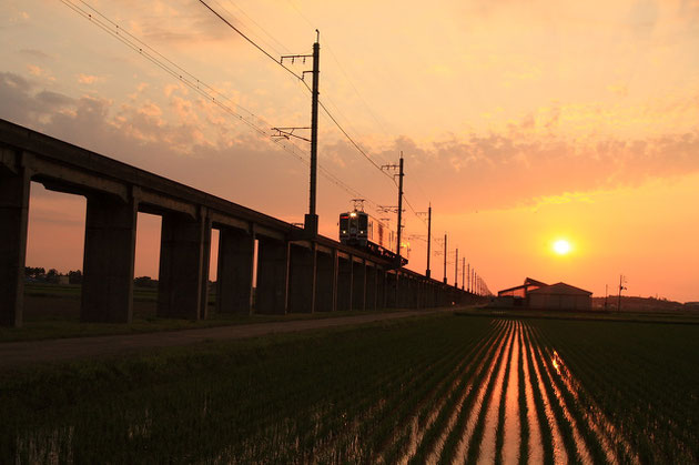 夕景 夕陽を背にくびき野を行く、間もなくくびき駅へ（ほくほく線）