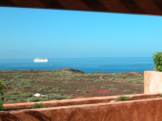 Auf dem Bild sehen Sie den Blick vom Apartment bis zum Meer, über den Küstenstreifen. Im Hintergrund am Horizont sieht man ein Fahrgastschiff. 