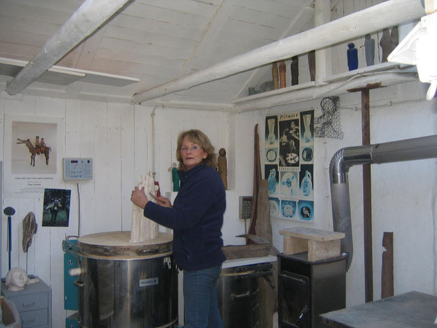 marianne schweigler in ihrem atelier, beim anfertigen einer tonskulptur. marianne schweigler steht vor ihrem brennofen