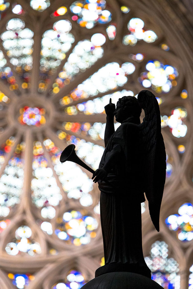 Angel statue with reminding hand in front of a the Cathedral Rosette Window, Metz, France, Europe 