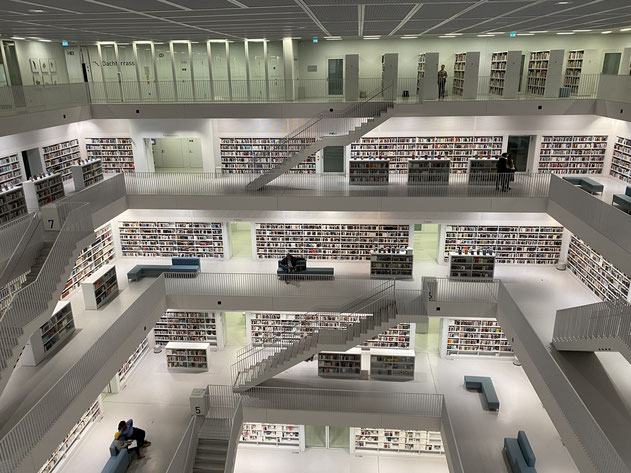 vista della biblioteca a piani bianca, con scalinate e libri, a Stoccarda