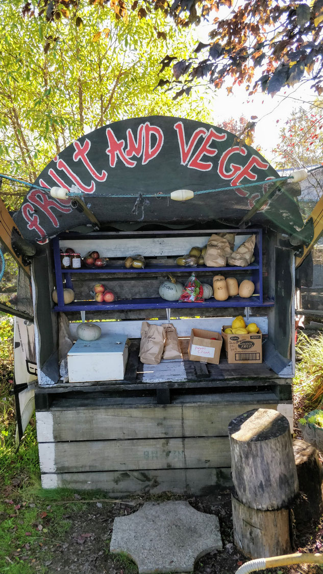 Un étal de particuliers et sa "honesty box" sous la citrouille sur la gauche