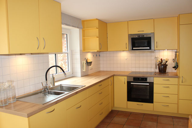Farbige Küche mit Dekor-Möbelbauplatte in maisgelb.