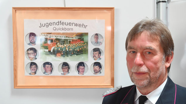 Das weckt Erinnerungen: Ehrenwehrführer Peter Stehr vor dem Foto der ersten Generation der Jugendfeuerwehr aus dem Gründungsjahr 1994