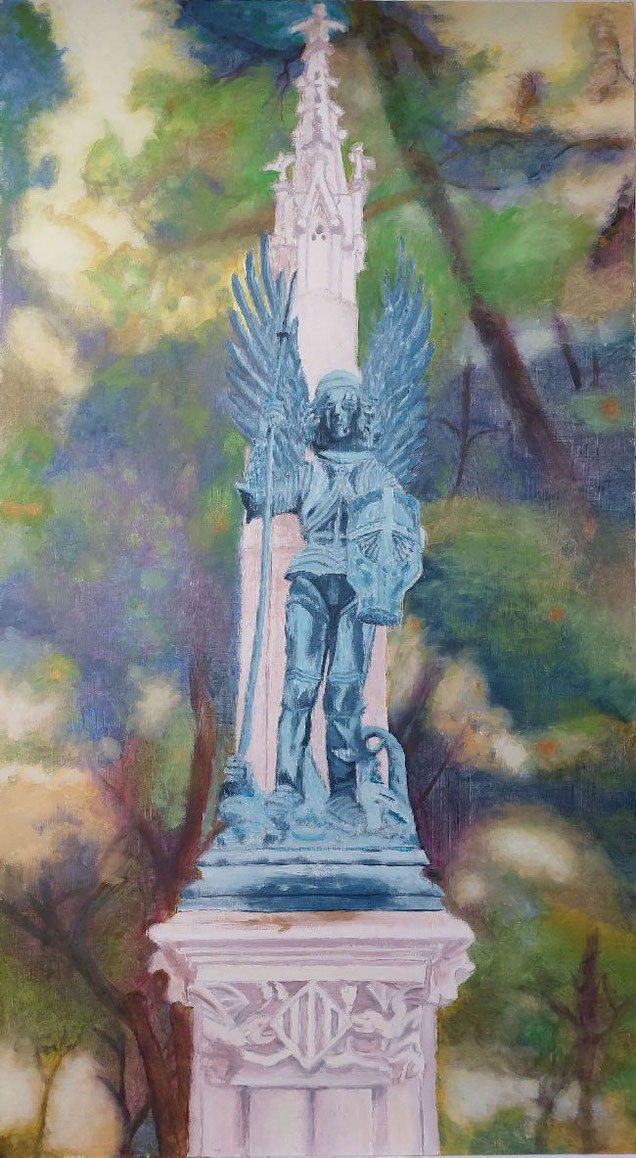 Estatua de San Miguel Arcángel con armadura y alas, sosteniendo lanza y escudo, sobre pedestal ornamental.