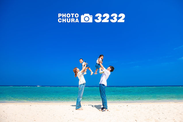 青い海青い空をバックにお父さんお母さんが高い高いしている沖縄家族写真のシーン