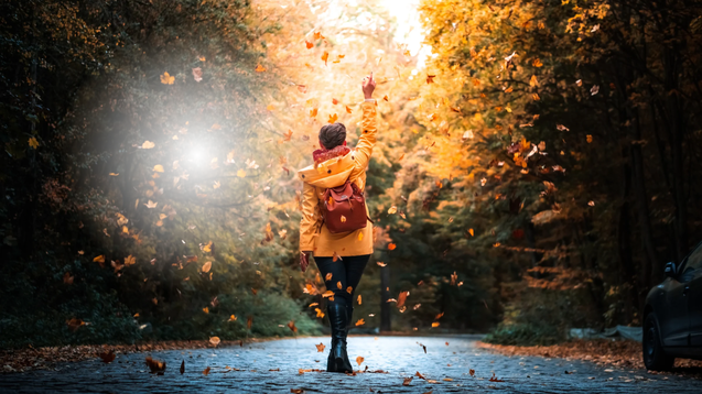 "Natürlich Frei: Entfalte dein volles Potenzial in der Natur." - Eine Person streckt den Arm triumpfierend im herbstlichen Wald aus, im Hintergrund.