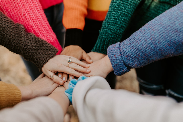 A group of people piling their hands together