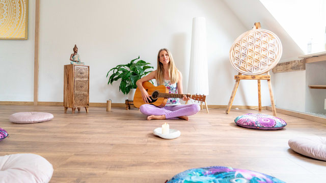 Foto von Melina mit Gitarre im Yogaraum