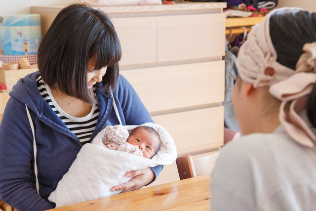 産前産後家事サポーターと赤ちゃんを抱っこしている母親が話している画像