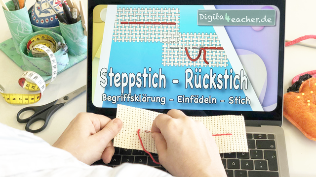 Schreibtisch mit Laptop und Handarbeitsmaterial, Lehrerin beim Sticken des Steppstichs oder Rückstichs