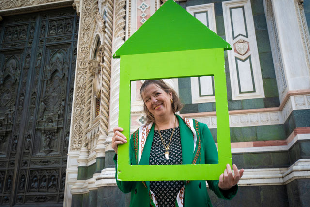 signora che sorride con logo verde di una casa