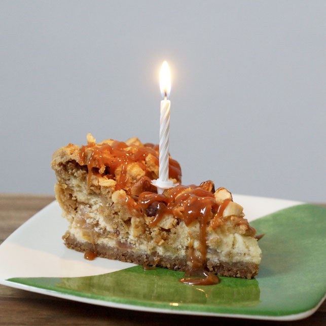 Apfel-Käsekuchen mit Streuseln und Karamell mit Geburtstagskerze