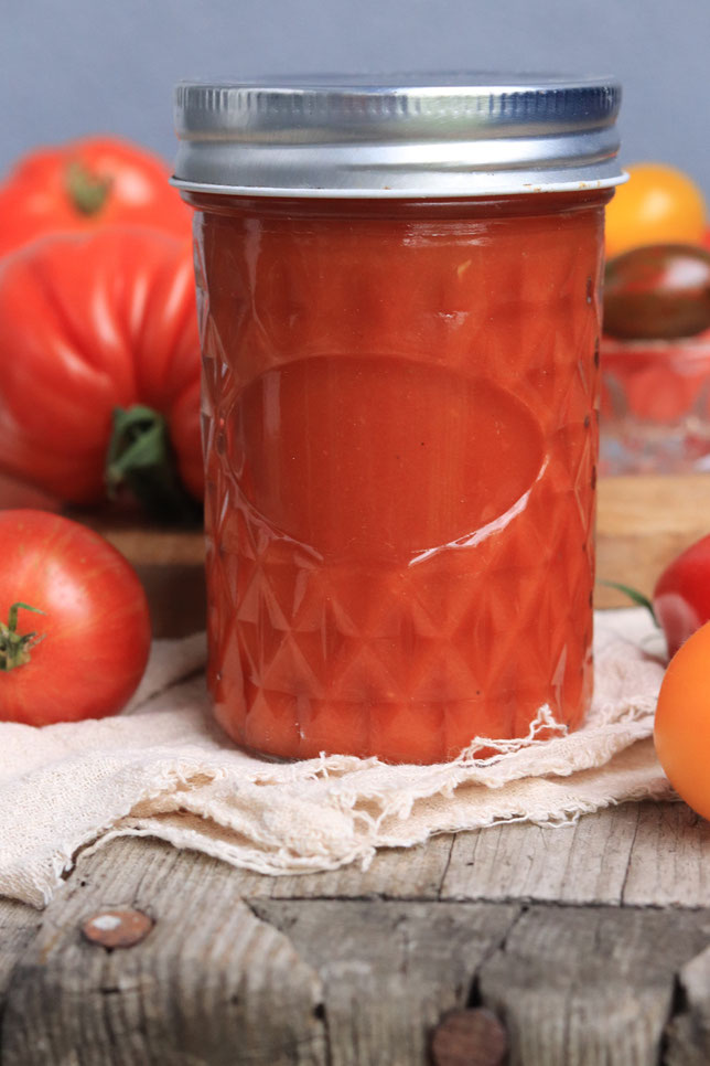 Ketchup im Glas und Tomaten