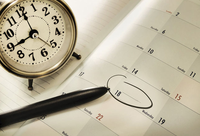 Eine Uhr, ein Kalender und ein Stift