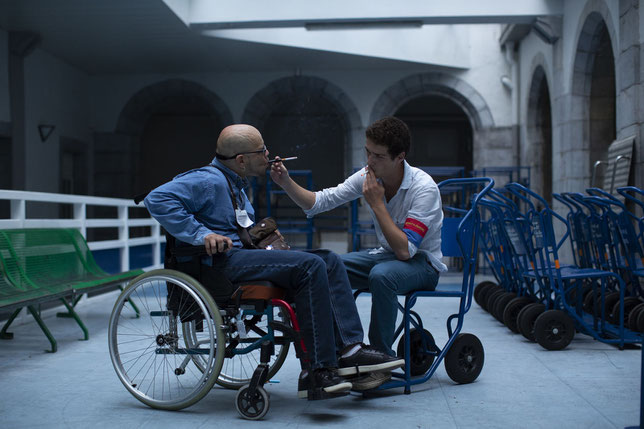 Un aide-soignant partage en cachette une cigarette avec le pèlerin paralysé dont il s'occupe (©Mars Films).