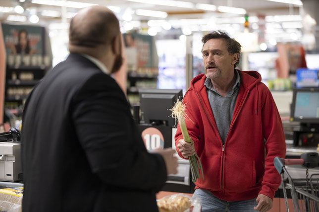 Fabrice (Jean-Paul Rouve) est pris à partie par un vigile à la caisse de son supermarché car il a oublié sa carte de fidélité (©Cécile Mella/Apollo Films).