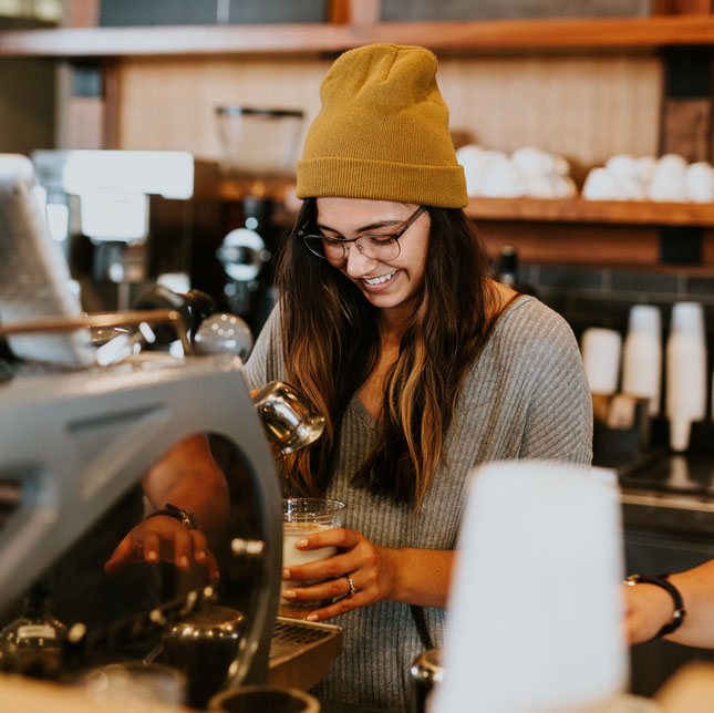 Freundliche Barista hinter der Espressomaschine
