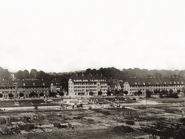 Die EBG-Siedlung an der Birs 1933. Neben dem Fussgängersteg über die Birs werden die Widerlager der neuen Redingbrücke gebaut.
