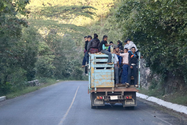 A truck full of people in the early morning heading to Coban
