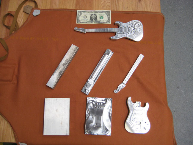 The various stages of machining the guitars with a US dollar bill for scale.