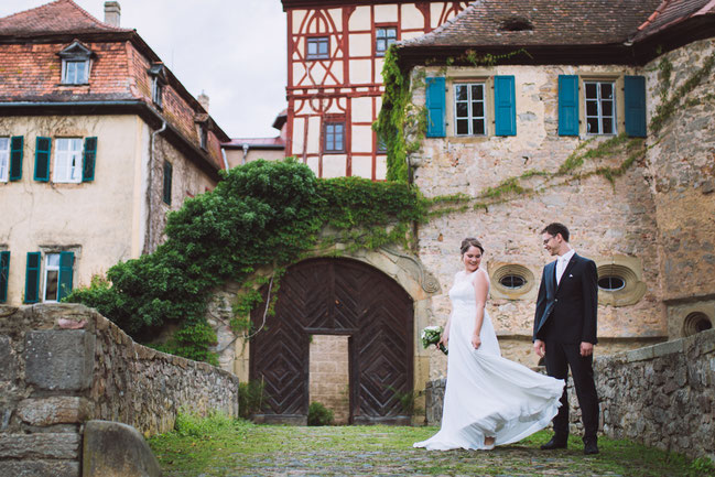 First-Look von Braut und Bräutigam vor der Kulisse des Wasserschloss Unsleben. Hochzeitsfotograf München