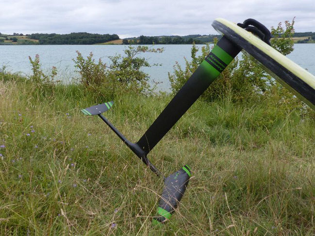 le windfoil aeromod version 2, noir et vert pomme, à la Ganguise au bord de l'eau avec son flotteur de planche à voile