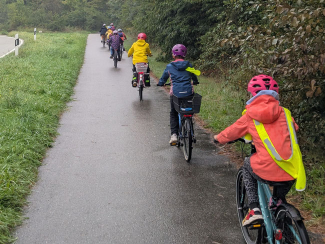 Kinder fahren im Regen Rad.