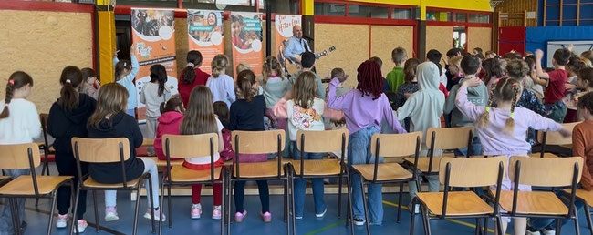 Jörg Schreiner lädt die Erstklässler zum Mitsingen und Mitmachen ein