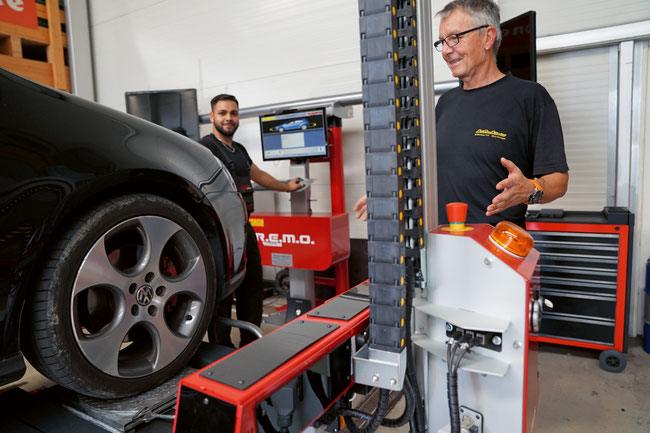 Reifenpraktiker Andreas Gozani und Thomas Schweizer bedienen das Hightech-Achsmessgerät der AutoPneu Schweizer AG in Oeschgen.