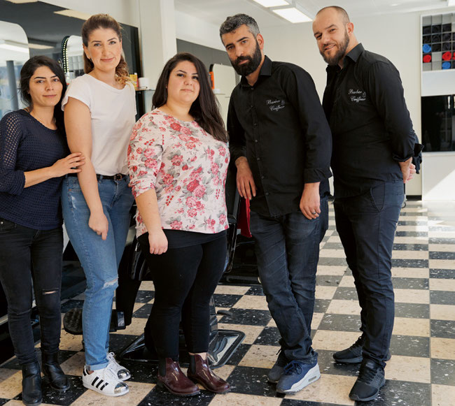 Die aufgestellte Istanbul Barber & Coiffeur-Crew in Stein mit Aycan und Murat Doymaz in der Mitte.