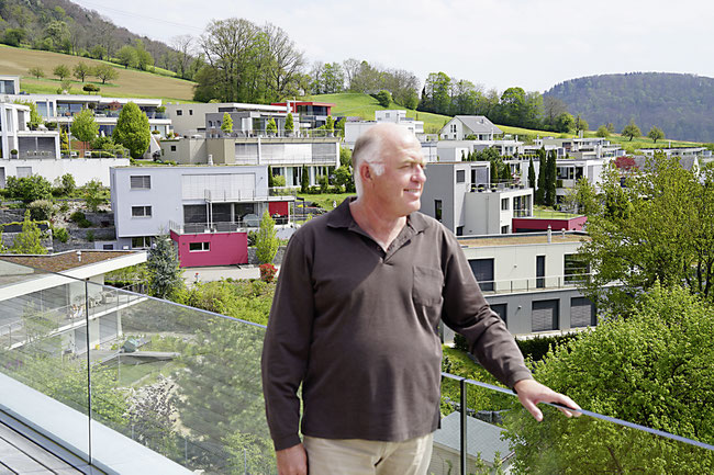 Architekt Peter Stocker in seinem Traumhaus in Frick, dahinter die von ihm entwickelte Frickberg-Überbauung.