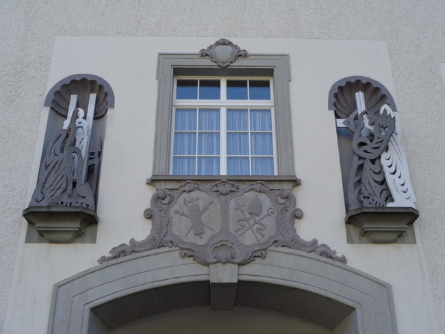 Portal zur Pfalz. Mitte: Wappen Kanton St. Gallern und Bistum. Links Skulptur St. Othmar, rechts Gallus.