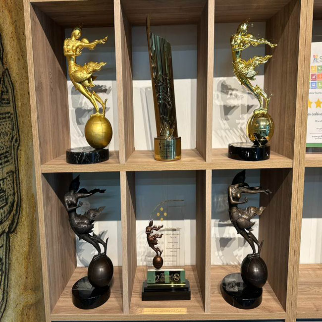 A shelf with 6 statues, representing the Thailand Tourism award