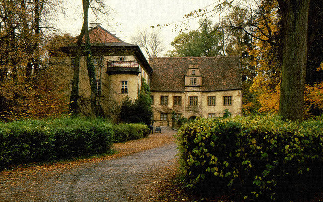 Schlosshof Fürstenau in Herbstfarben mit Schlossgärtner, der Laub aufsammelt ohne Laubbläser
