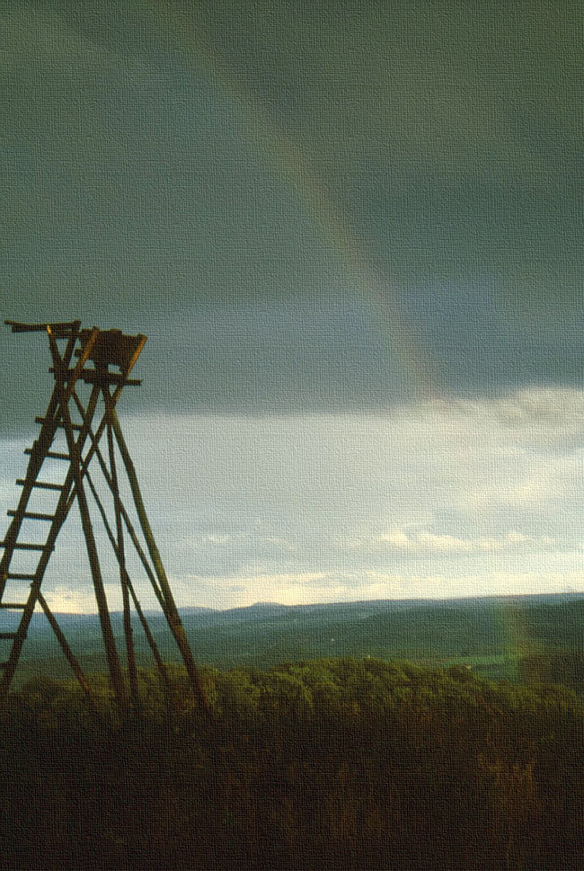 blasser Regenbogen über Hochsitz und bayerischer Rhön