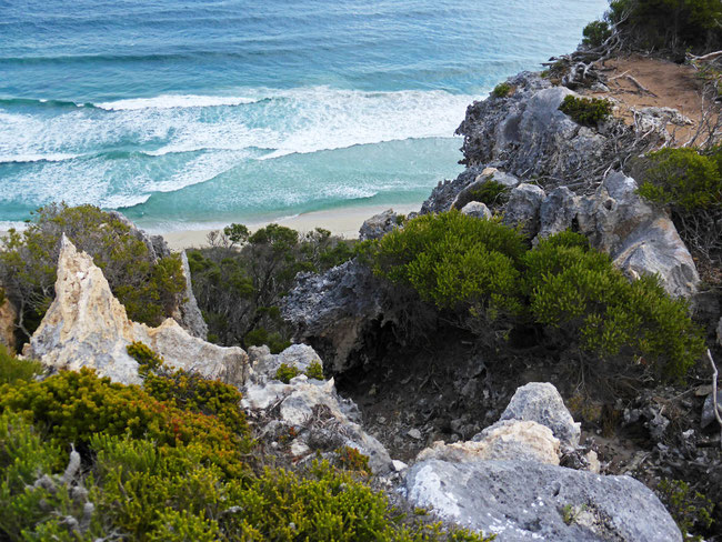 Looking down the limestone cliff face to the sea and beach below 