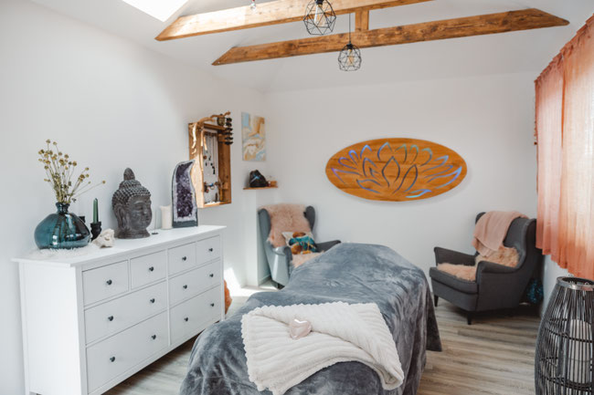 Heller Praxisraum in Hamburg – Reiki-Liege, gemütliche Sitzgelegenheit, friedvolle Energie.