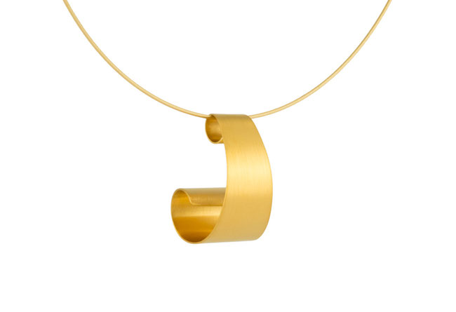 Der wunderbar leichte, geschwungene Anhänger ONDINE ist außergewöhnlich und stilvoll, gleichzeitig angenehm dezent. Das goldplattierte Silber reflektiert seidig glänzend das Licht. Durch die Windung entsteht ein raffiniertes Spiel aus Licht und Schatten