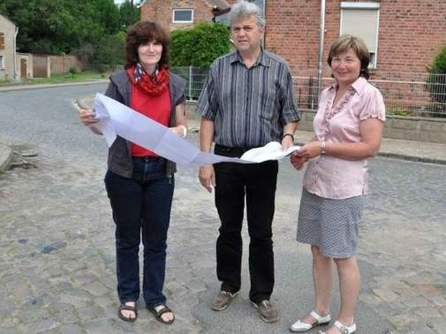 Katrin Otto (links) vom Bauamt der Verbandsgemeinde Westliche Börde zeigt Bürgermeisterin Eva Stroka und Leader-Manager Wolfram Westhus die Pläne für die Sanierung der Gunsleber Straße "Zickzack", in der sich die drei hier befinden