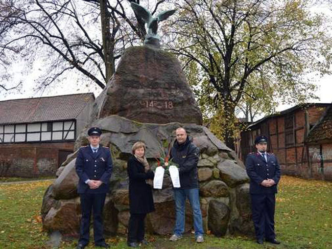 Sie haben im Beisein von weiteren Dorfbewohnern vor dem Gunsleber Kriegerdenkmal einen Kranz niedergelegt: Mathias Lange (von links), Eva Stroka, Rüdiger Buchholz und Toni Deutschmann. Hoch oben befindet sich der neue Adler.