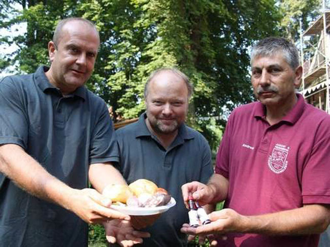 Rüdiger Buchholz, Dirk Slotta und Andreas Kasper (v. li.) präsentieren die Hausschlachtewurst und Schnäpse wie das Gunsleber Löschwasser, Gunsleber Schmetterball und den Gunsleber Tischtennistropfen. 