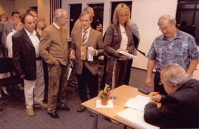 Auch Landrat Burkhard Kanngießer (Mitte) hat sich in die Reihe der Leser gesellt, die sich ihr Buch signieren ließen.