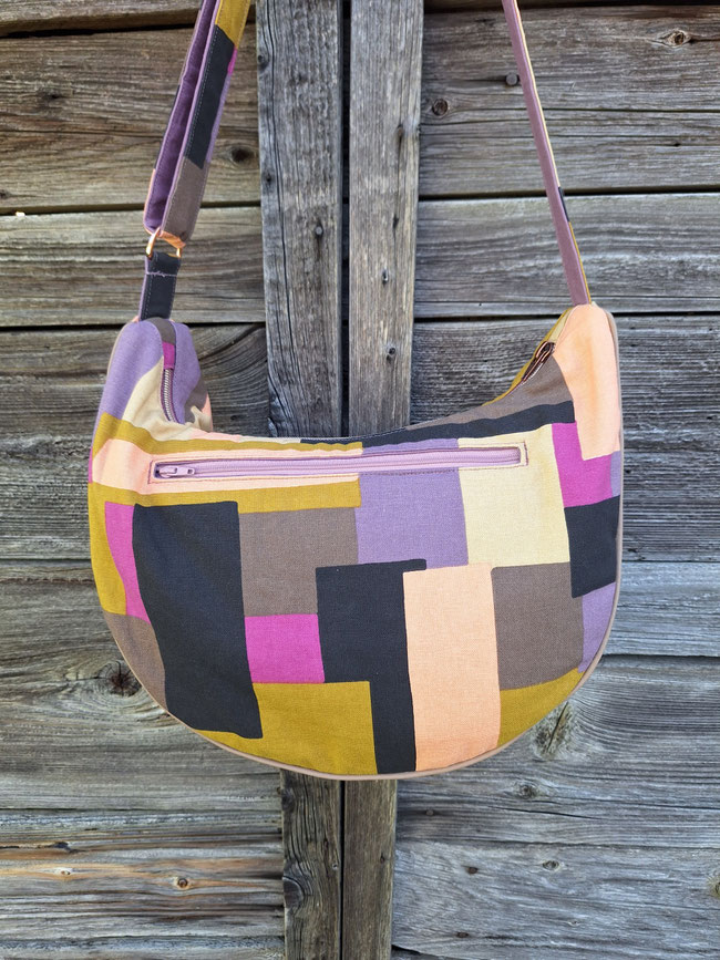 sac à bandoulière demi-lune en toile de coton avec blocs géométriques, doublure toile mauve, plusieurs poches, bandoulière règlable, idée  cadeau fête des mères anniversaire, fait-main en  Alsace