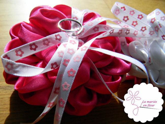 Bague de fiançailles posée sur coussin d'alliances en fleurs