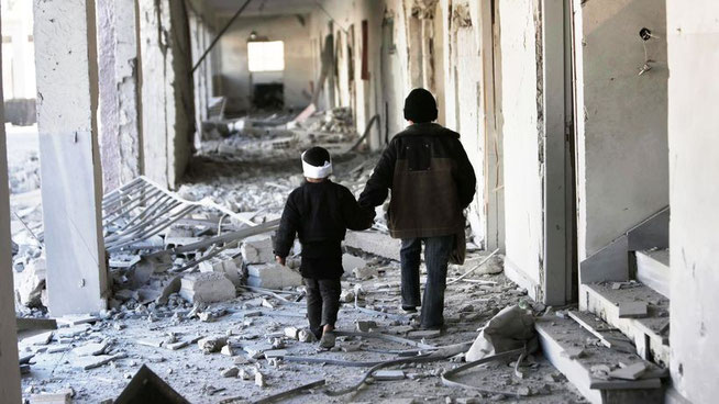  Kinder in Syrien gehen durch eine zerstörte Schule. © AP/dpa 