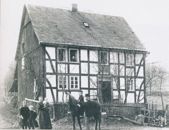 Das 1833 erbaute Wohnhaus des Franz Poggel. Das wurde 1959 abgebrochen. Auf dem Foto, vermutlich um 1920, sind Angehörige der Familie Vollmer zu sehen.