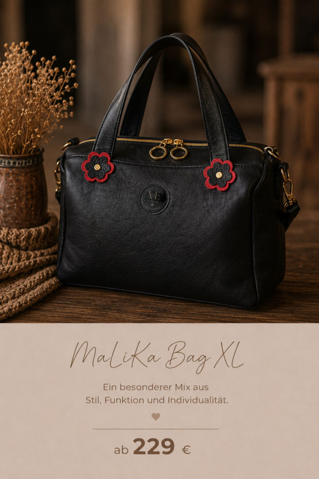 MaLiKa Bag XL von Viola Engler reloved aus schwarzem Leder mit goldfarbenem Reißverschluss, roten Lederblümchen und handgefertigten Details. Die Tasche verbindet zeitloses Design mit Funktion und Individualität.