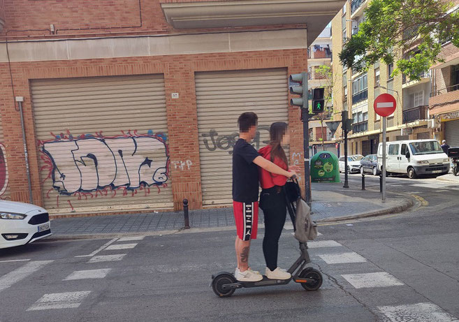Aquí vemos varias infracciones, prohibido dos en un patinete y saltándose el semáforo en rojo en Valencia.