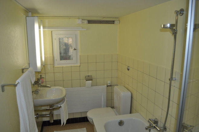 Bad in frischem Gelb-Weiss mit Badewanne/Dusche und WC